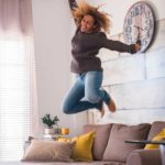 surging asx ecommerce share price represented by woman jumping off sofa in excitement