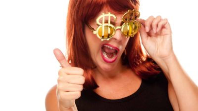 woman wearing bling gold glasses with dollar signs happy about making share price gains