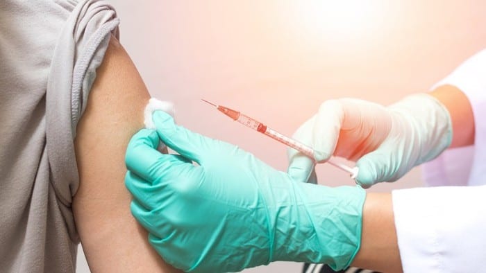 person receiving coronavirus vaccine injection into the arm
