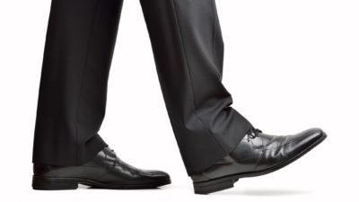 follow warren buffett when buying asx shares represented by business man's legs walking along
