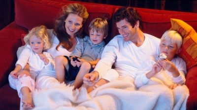 netflix shares represented by family of four relaxing on the couch watching tv
