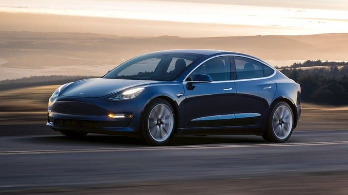 Image of a Tesla vehicle driving along an open road