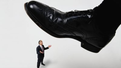 asx share resignation represented by giant shoe about to step on reluctant miniature business man