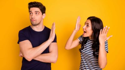 A couple young arguing against a yellow backdrop, indicating a tussle over business decision