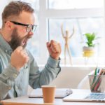 investor looking excited at rising fortescue share price on laptop