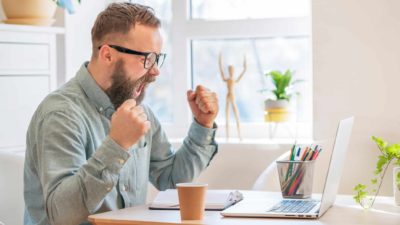 investor looking excited at rising fortescue share price on laptop