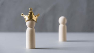asx shares management represented by wooden peg doll wearing gold crown