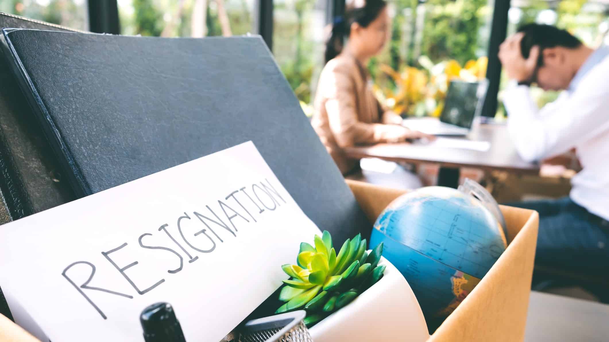 asx share executive resignation represented by resignation letter and personal items in box on desk