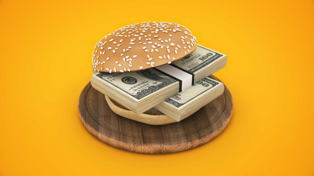 Burger bun around two wads of cash to symbolise food dividend shares