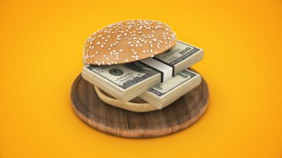Burger bun around two wads of cash to symbolise food dividend shares