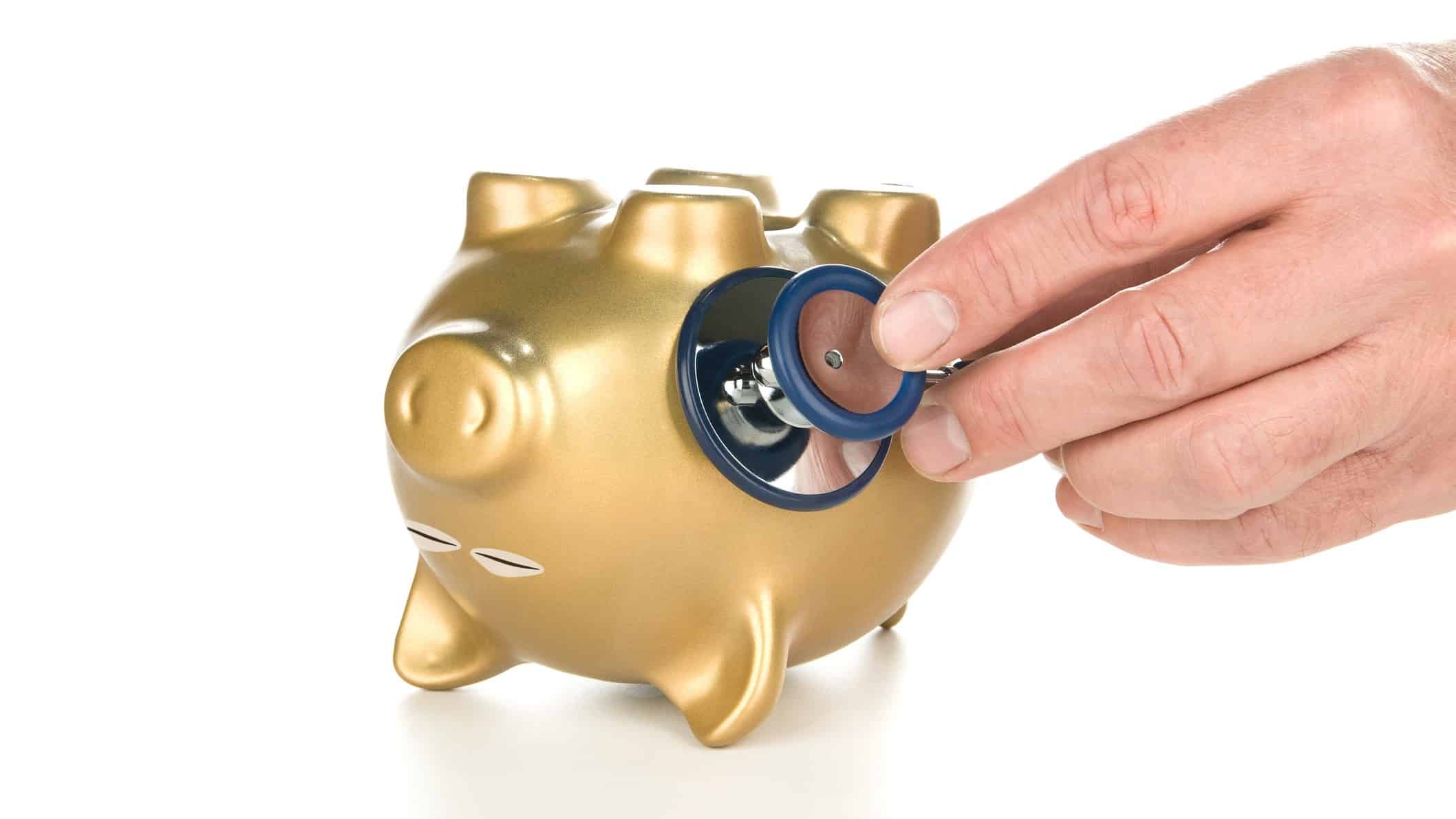 whether recessions cause deaths represented by docotor checking heart rate of upturned piggy bank