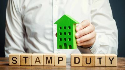 asx investor placing wooden house block on other blocks spelling words stamp duty