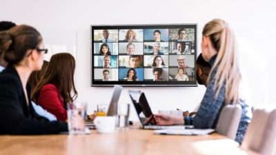 Business people in an office holding a Zoom meeting