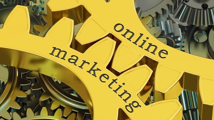 Yellow cogs of a wheel with 'online marketing' written on them in black lettering
