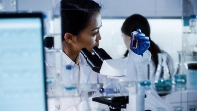 Female scientist in lab examines coronavirus vaccine