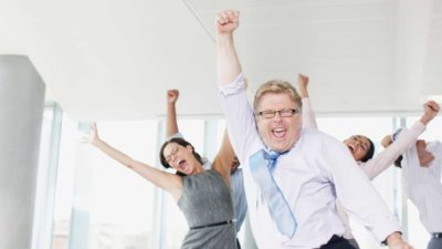 Good news has these businesspeople cheering for joy, partying in a board room.