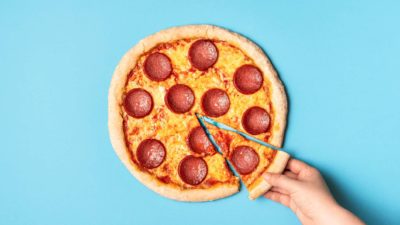 asx pizza share price represented by hand taking slice of pizza