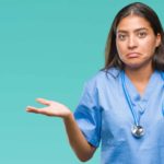Doctor with stethoscope around neck shrugging.