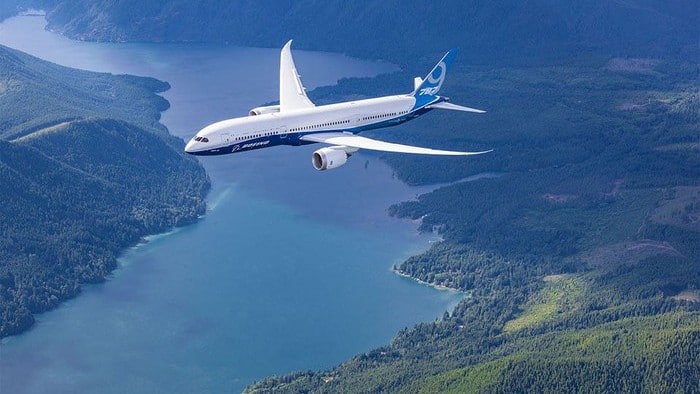 A Boeing plane flying over a lake