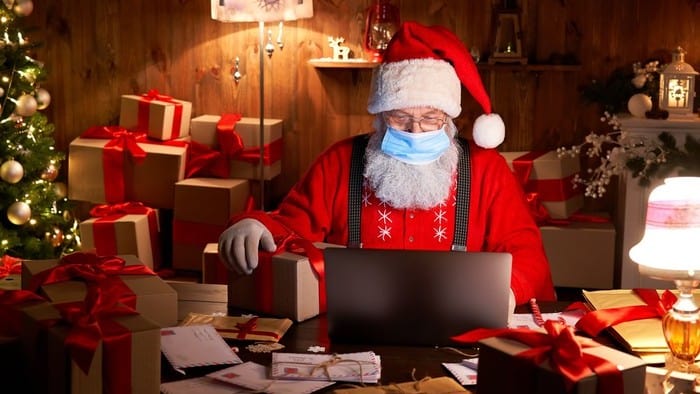 ecommerce asx shares represented by santa doing online shopping on laptop