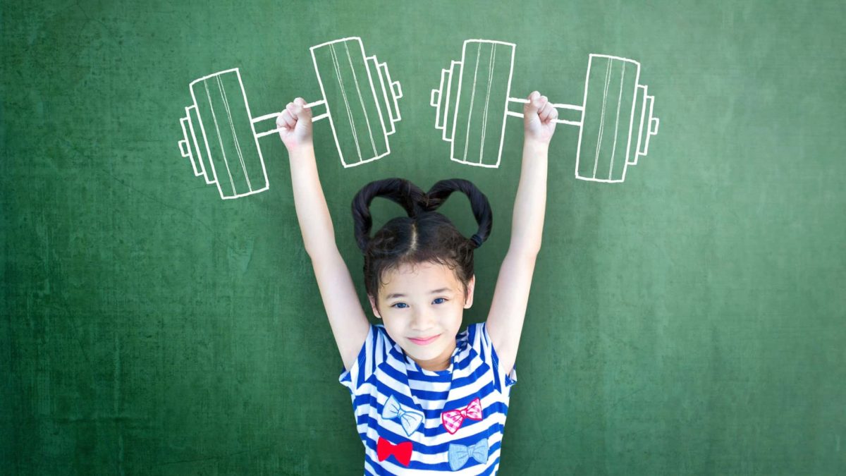 A young girl stands in front of a chalk board pretending to lift big weights drawn in chalk, indicating a small cap share lifting above its weight