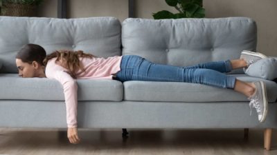 A woman lying face down on the couch, indicating a flat ASX share price.