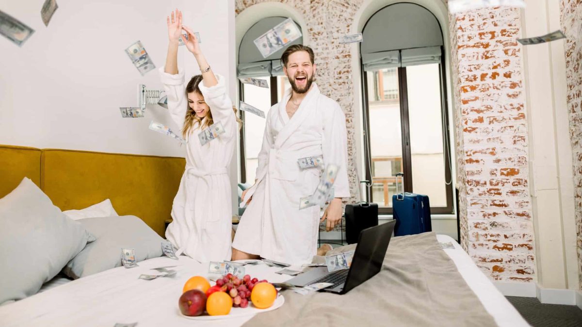 Free shares represented by two people throwing money in the air on a bed