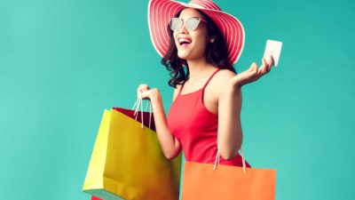 A happy shopper with lots of bright shopping bags, indicating a positive surge for ASX retail share price