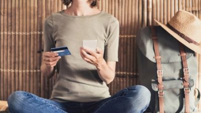 woman using credit card to make online purchase on mobile phone