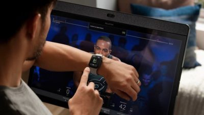 peloton shares represented by man syncing smart watch with computer app