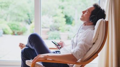 streaming stock represented by man relaxing in chair listening to music