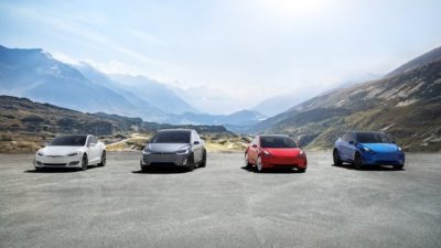 tesla stock represented by four tesla cars parked on mountain top