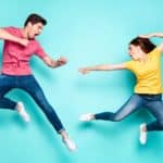 Two people jump in the air in a fighting stance, indicating a battle between rival ASX shares
