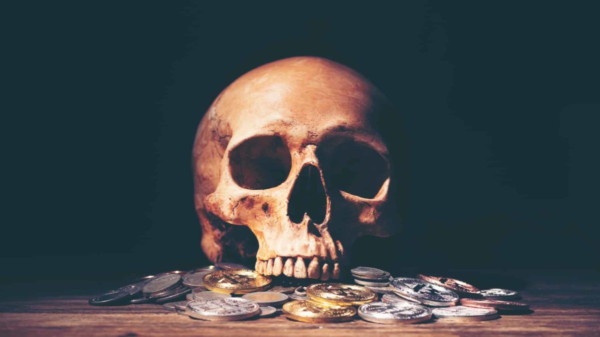 Stack of coins with skull representing concept of business death