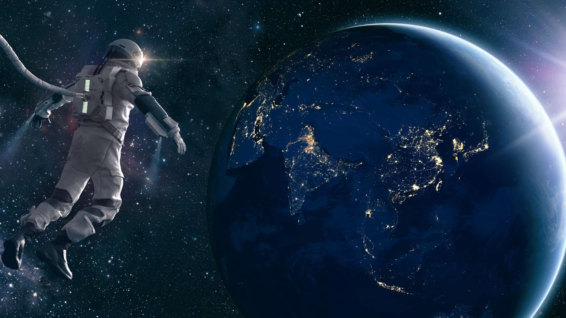 Astronaut floats in space looking down on Earth