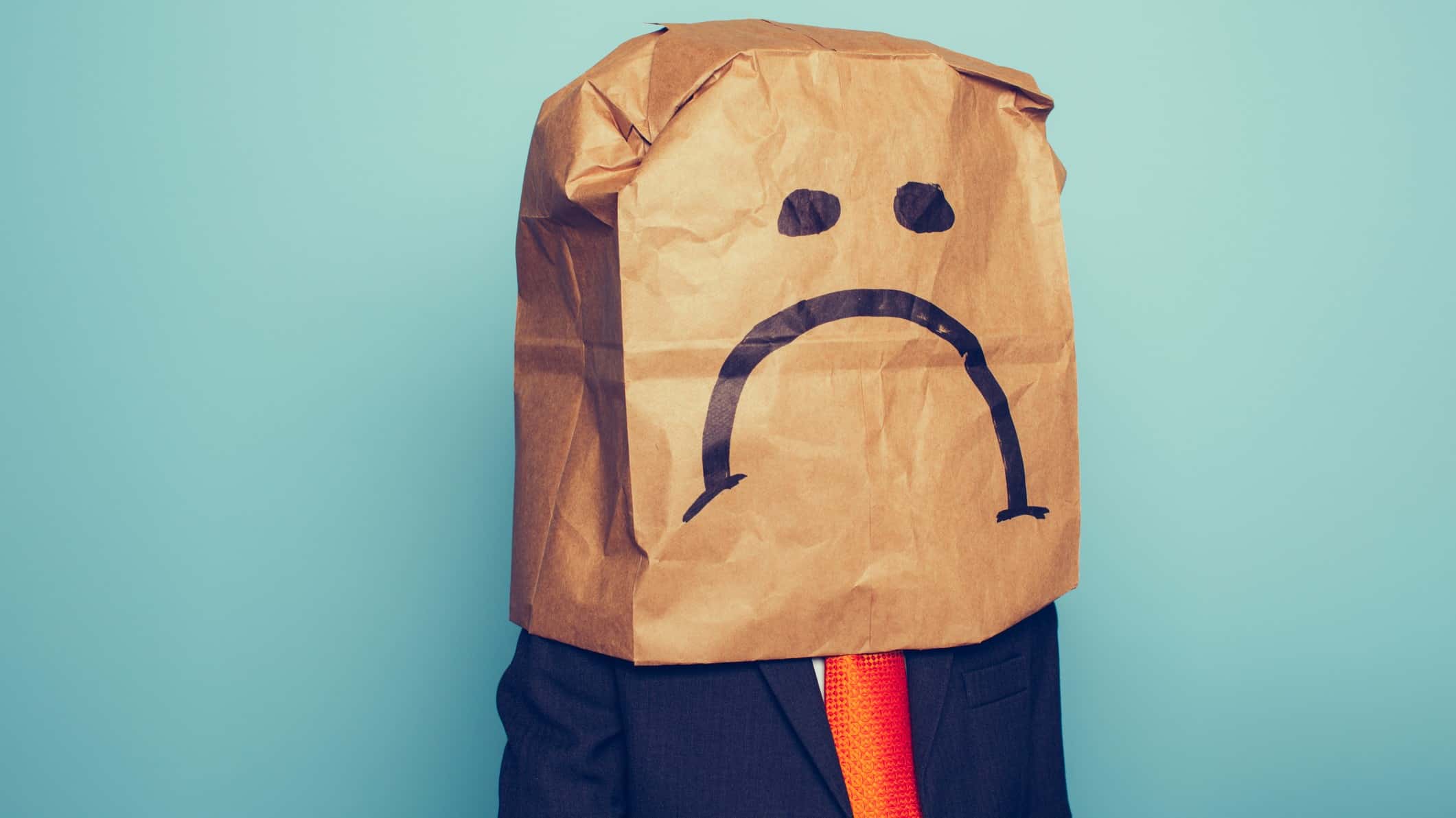 asx shares falling lower represented by investor wearing paper bag on head with sad face