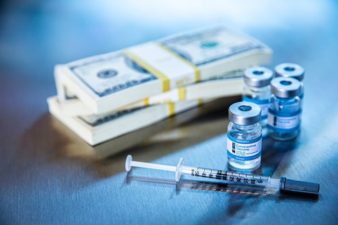 coronavirus stocks represented by vaccine vials alongside piles of cash