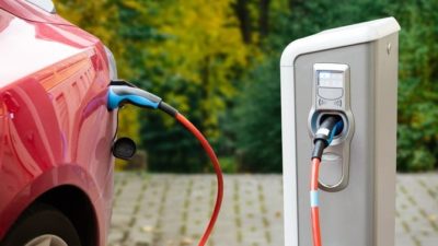 electric vehicle such as Tesla being charged at charging station