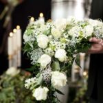 funeral asx share price represented by man holding flowers at a funeral