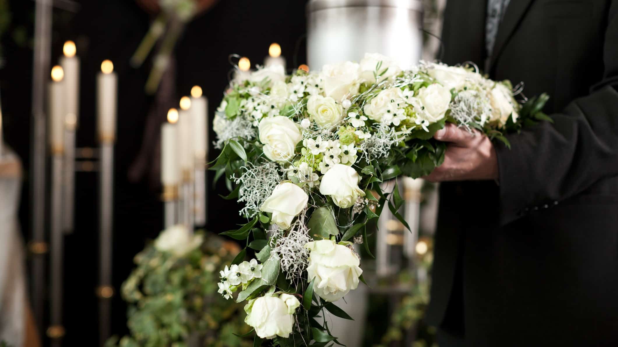 funeral asx share price represented by man holding flowers at a funeral