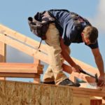 building and construction shares represented by man on roof of construction site