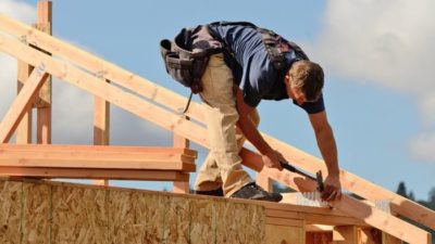 building and construction shares represented by man on roof of construction site