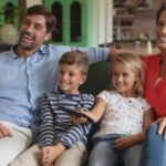 A family sitting on a couch watching Netflix