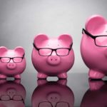 A row of pink piggy banks ranging in size from small to big.