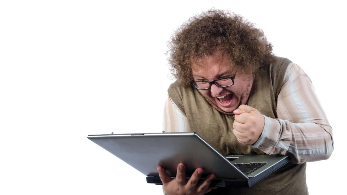 excited investor making fist at computer screen