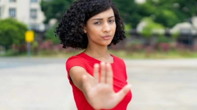 ASX share price trading halt represented by serious woman putting hand up