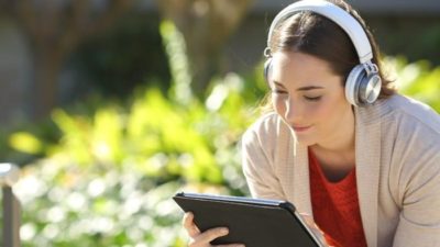 streaming stocks represented by woman watching tv on tablet