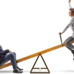 Two people on a seesaw.