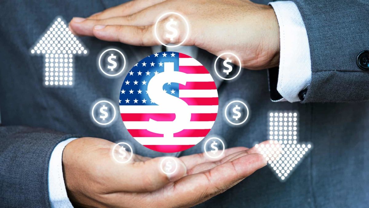 A businesman's hands surround a circular graphic with a United States flag and dollar signs, indicating buying and selling US shares