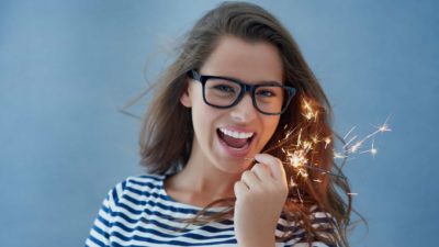 asx share price spark represented by smiling lady holding sparkler